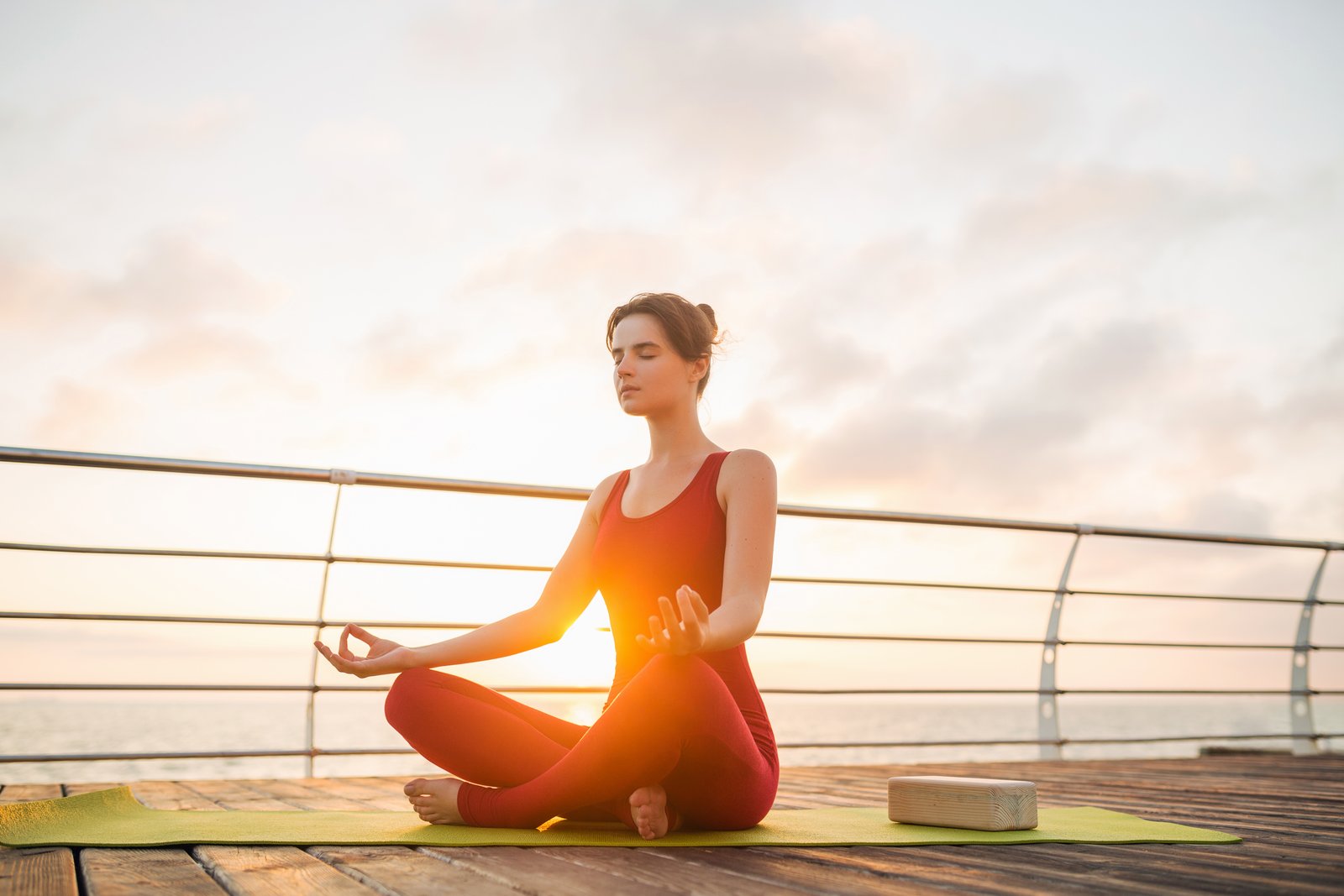 Instructor in a serene warrior pose at sunrise